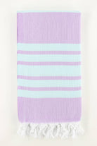 A stack of folded Turkish towels in various solid colors including green, blue, pink, red, gray, and white, displaying the herringbone texture.