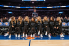 Group of women in matching outfits sitting on a basketball court